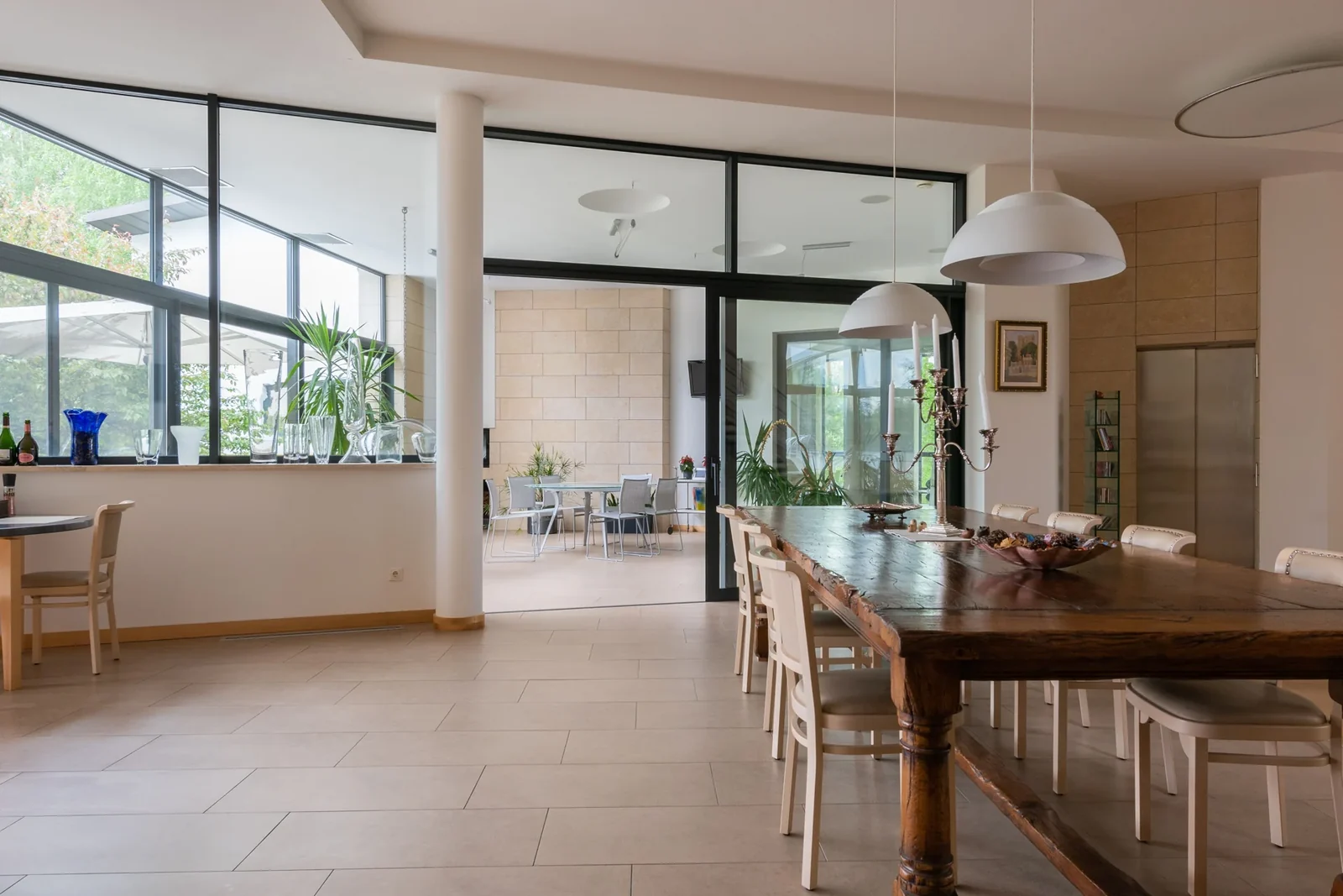 Bright dining room with a wooden table, chairs and large windows.