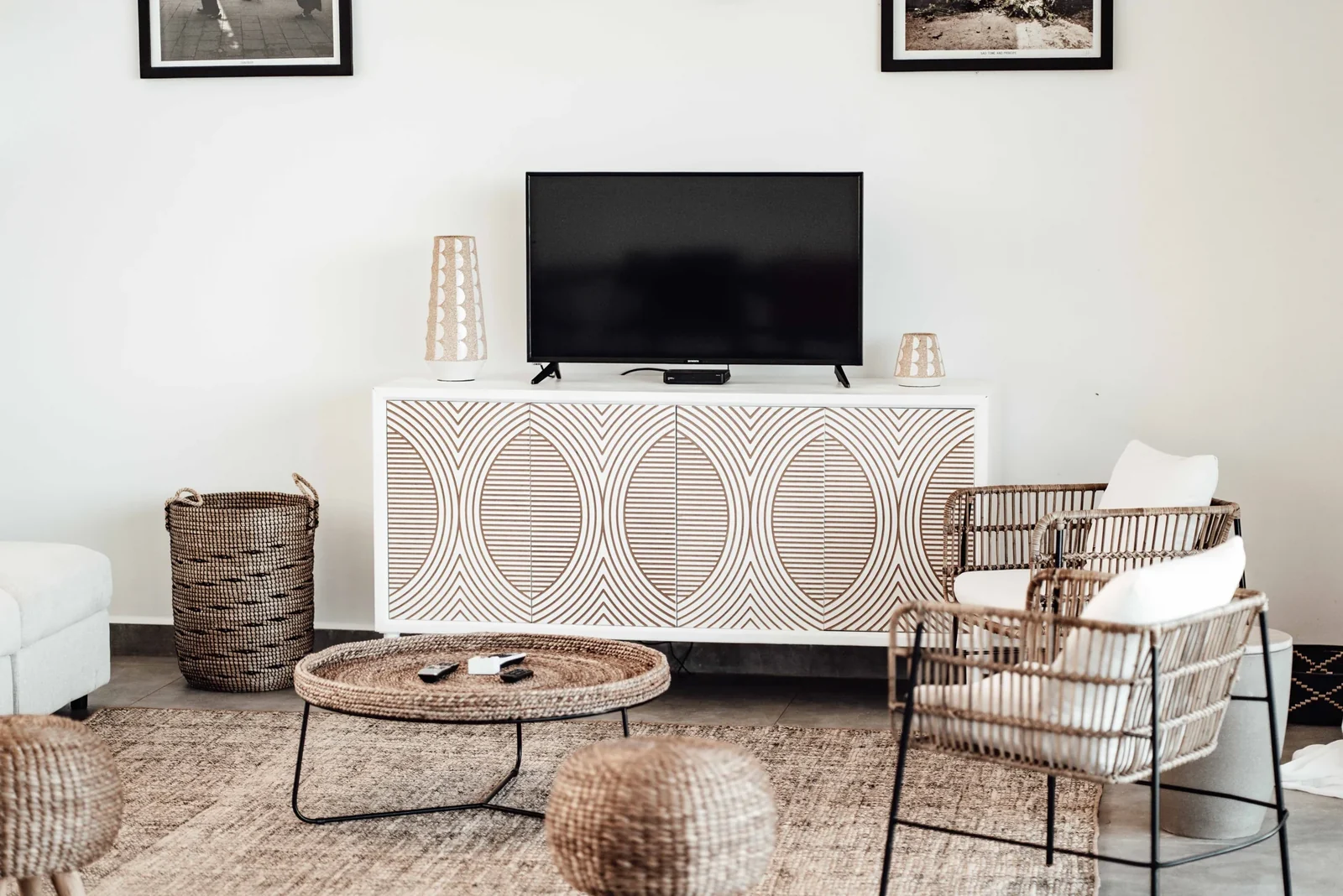 Living room with rattan chairs, a woven basket, and a television.