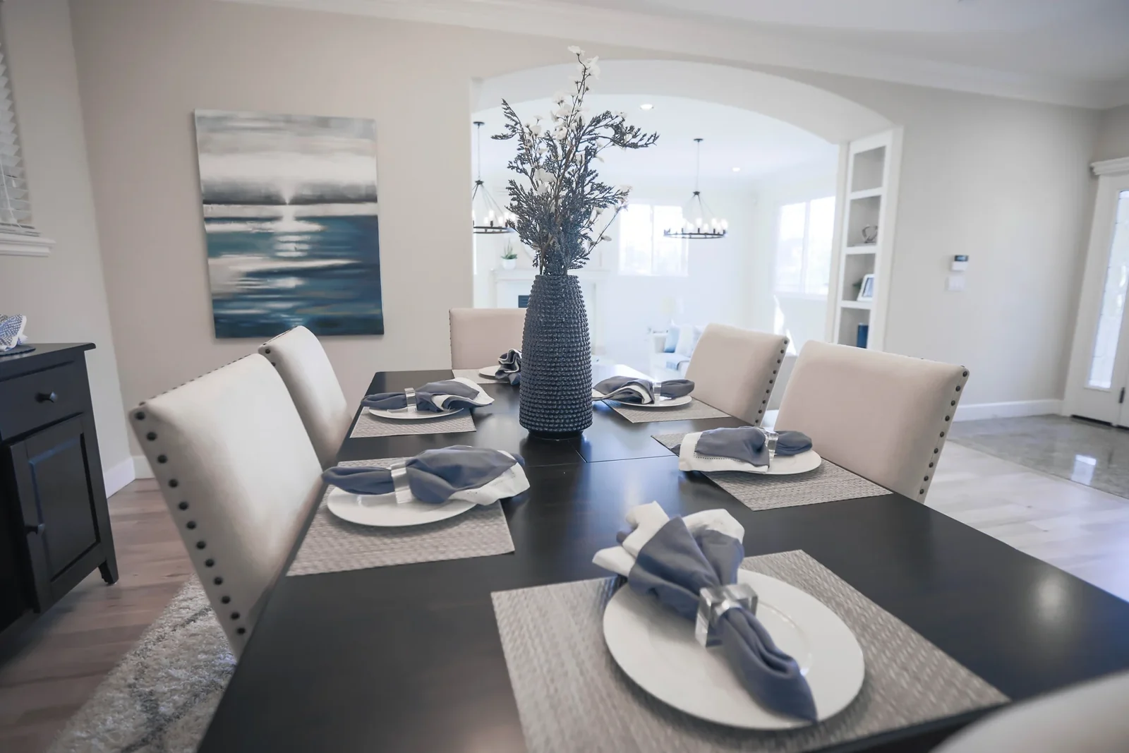 Dining room with a set table, blue plates and neutral furnishings.