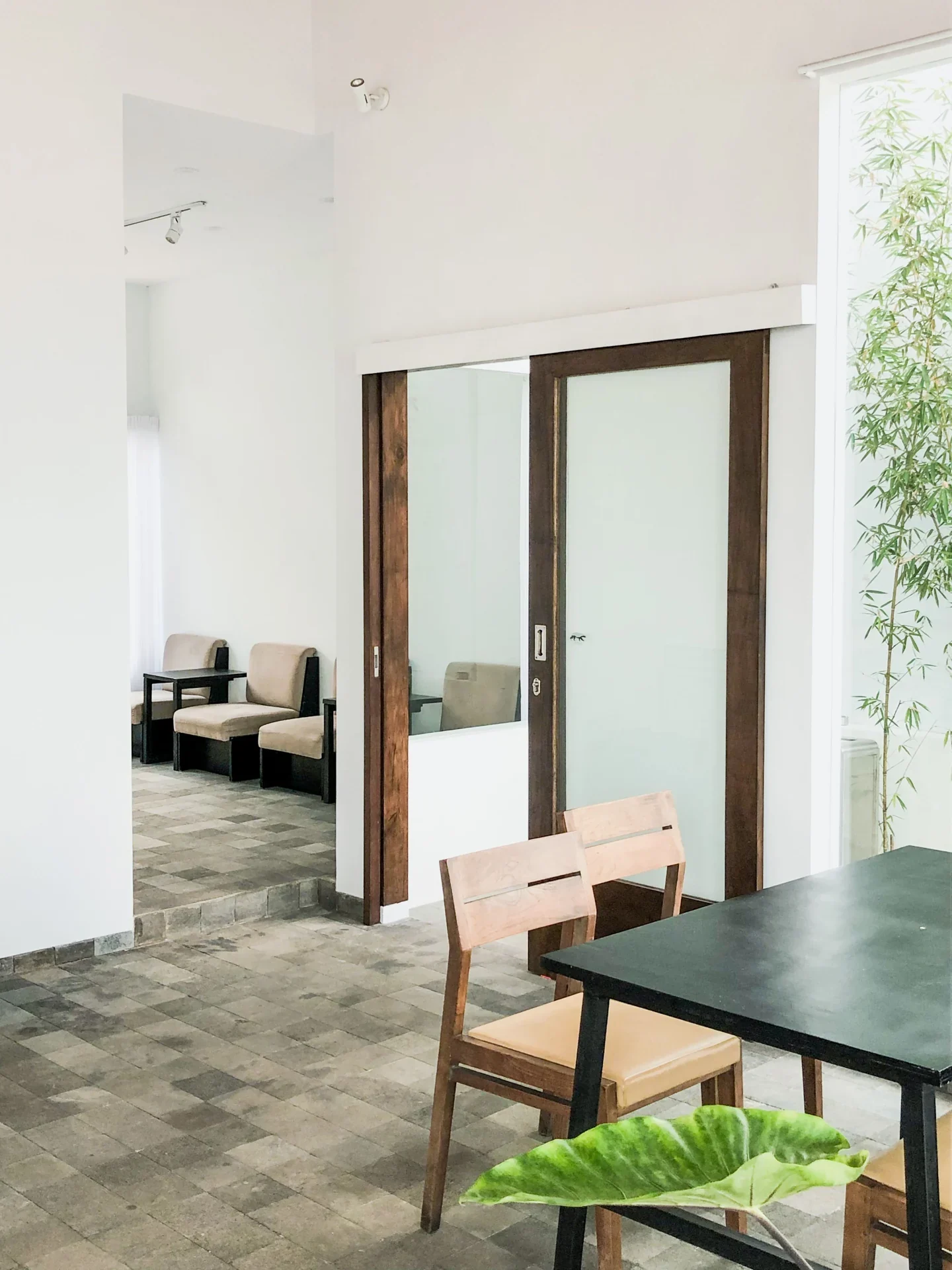Dining area with a wooden table, chairs, and sliding glass doors.