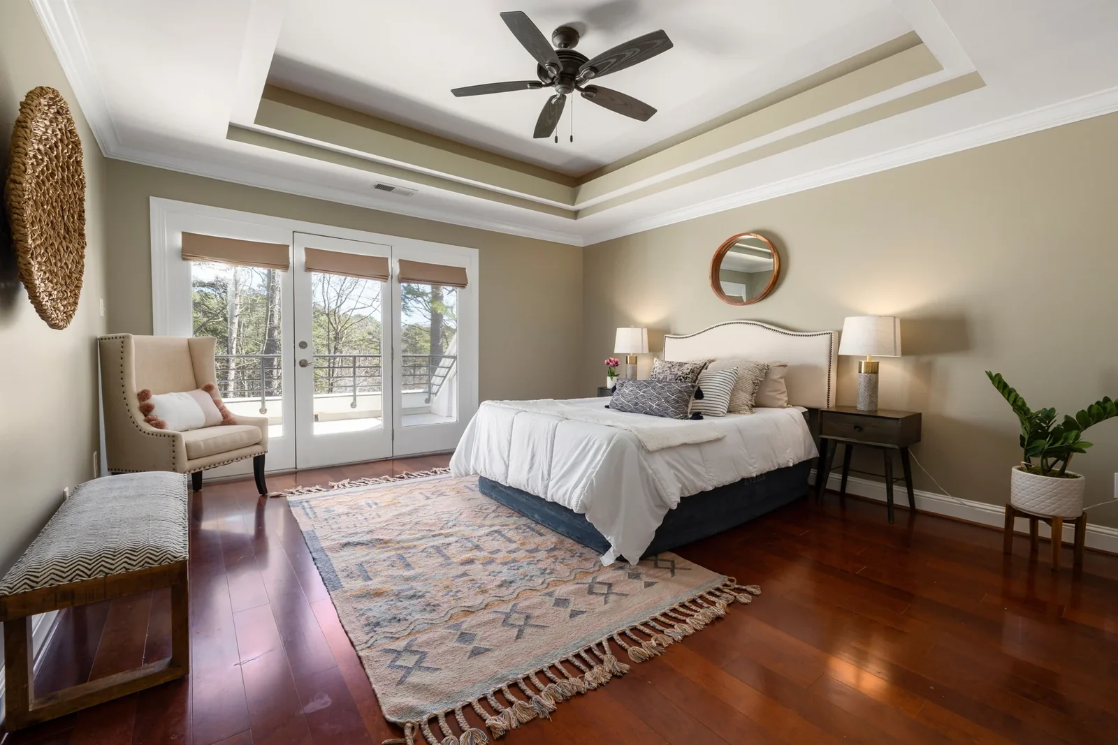 Spacious bedroom with a bed, carpet and natural light from windows.