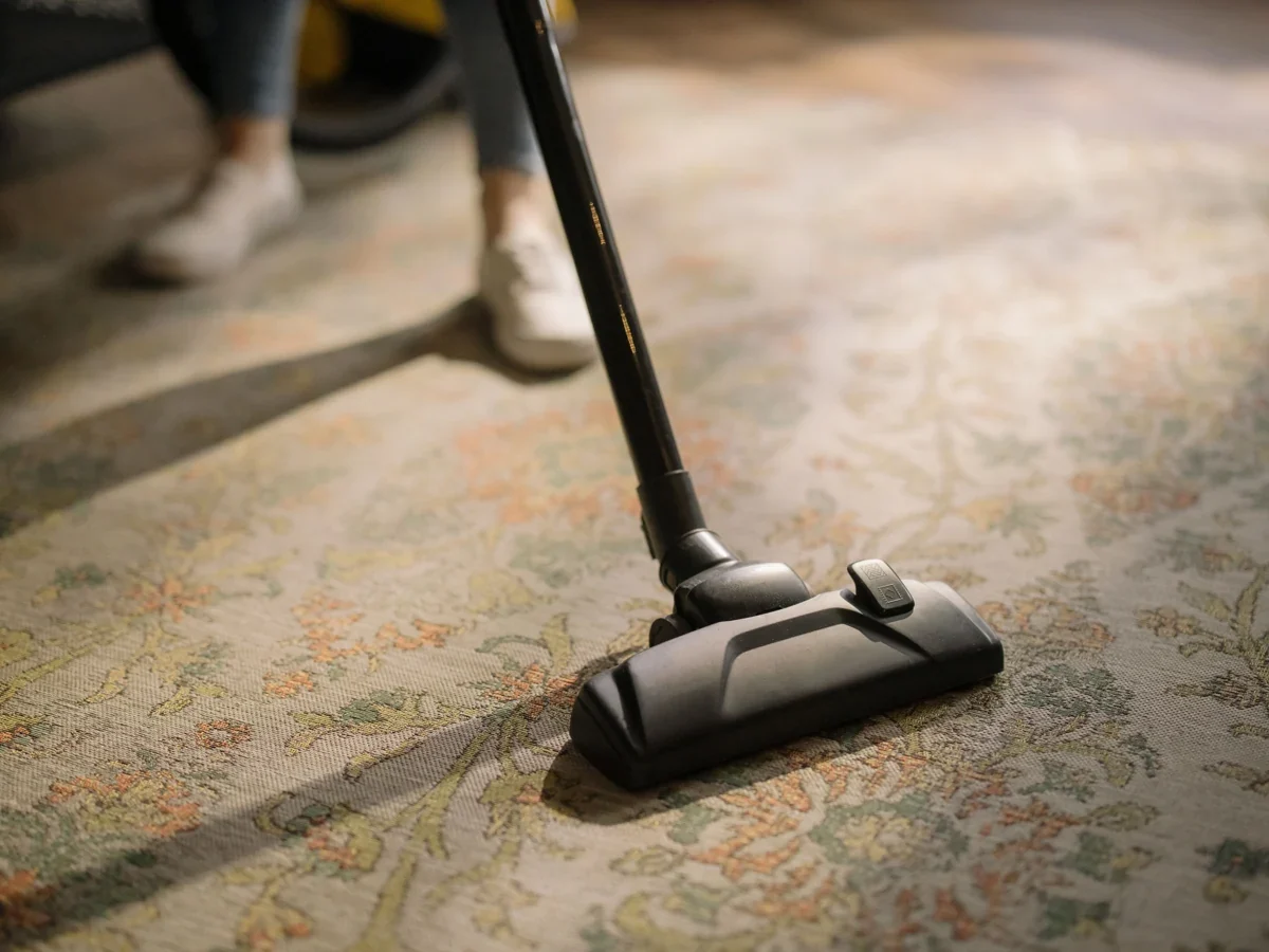 A vacuum head cleaning an area rug