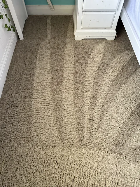 Fitted bedroom carpet after cleaning: The same room with fewer visible spots and clear grooming lines across the carpet.