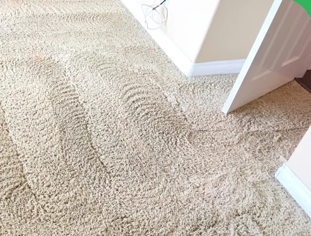 Carpet at a bedroom doorway after cleaning: The same doorway with lighter-looking carpet and visible grooming marks.