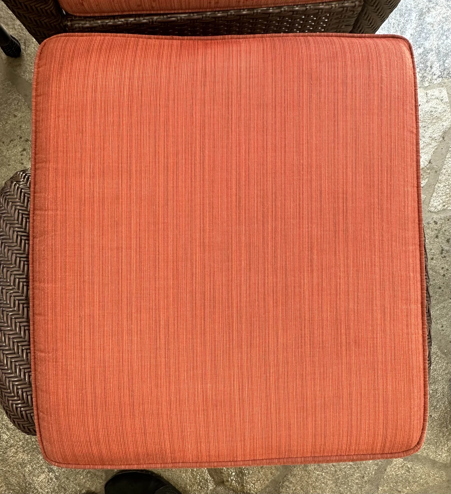 Coral upholstered seat cushion after cleaning: The same cushion with fewer visible marks and a more even-looking color.