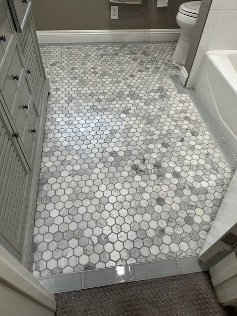 Hexagonal bathroom tile and grout after cleaning: The matching mosaic floor with a more even-looking appearance across the grout.