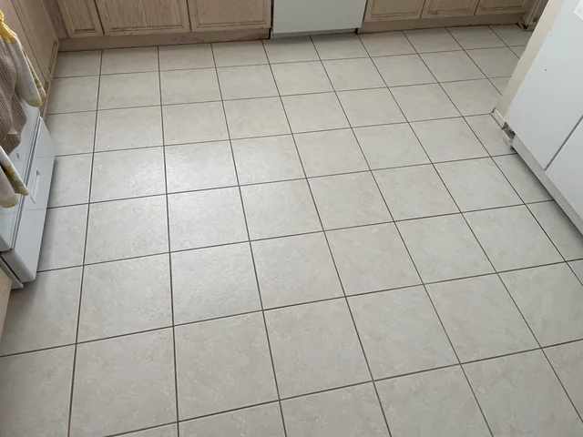 Square floor tile and grout after cleaning: Lighter-looking grout lines and a more consistent appearance across the kitchen tile.