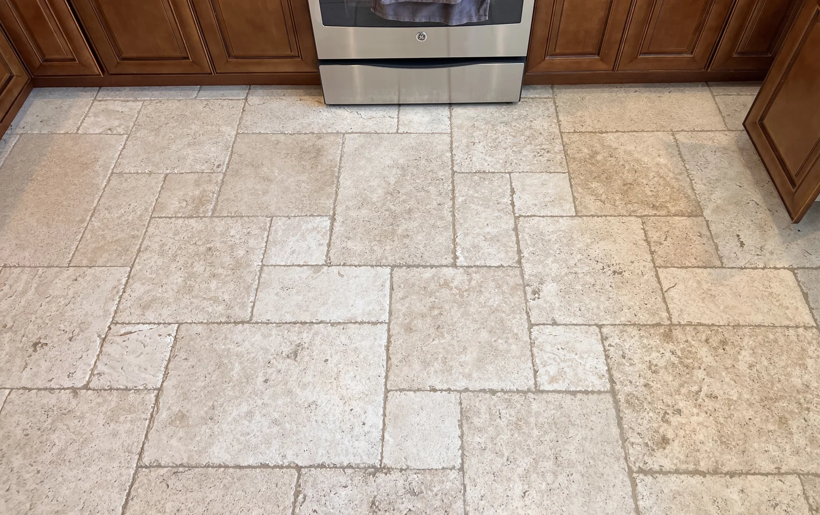 Patterned floor tile and grout after cleaning: The tile pattern looks more defined, with lighter-looking grout lines between the pieces.