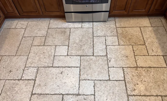 Patterned floor tile and grout before cleaning: Dark grout lines and uneven-looking soil across a kitchen’s patterned tile.