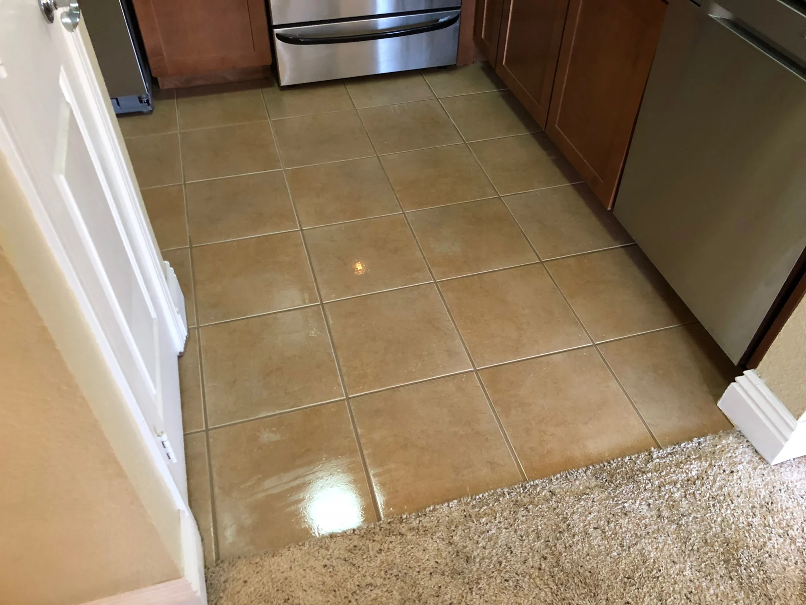 Square kitchen tile and grout after cleaning: Lighter-looking grout lines across the same kitchen floor.