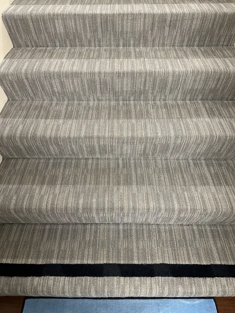 Striped stair carpet after cleaning: The same striped staircase with fewer visible specks across the treads.