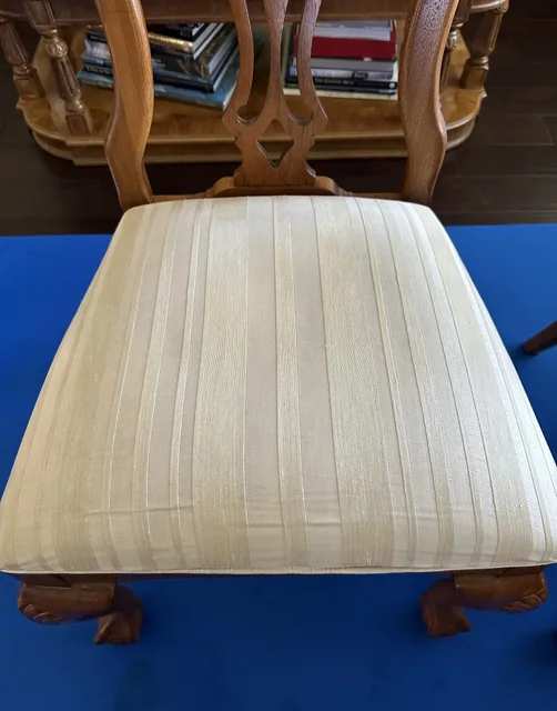 Striped upholstered dining-chair seat after cleaning: The same striped seat with fewer visible marks across the fabric.