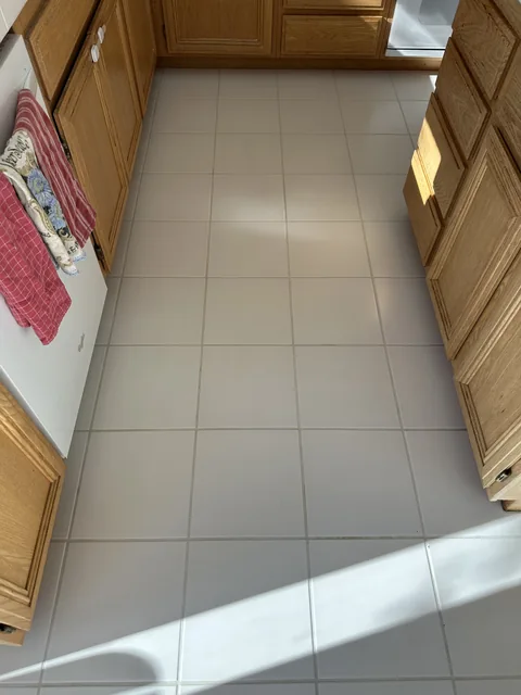 White square kitchen tile and grout after cleaning: Lighter-looking grout and fewer visible marks across the same white tiles.
