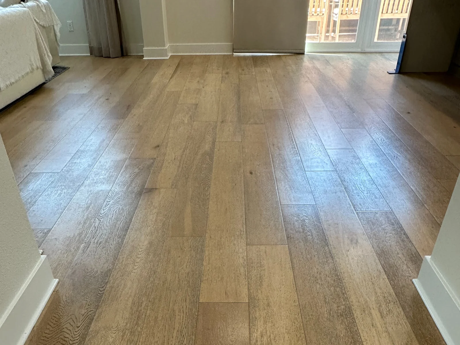 Wood-look plank flooring before cleaning: A plank floor with a dull, uneven-looking surface.